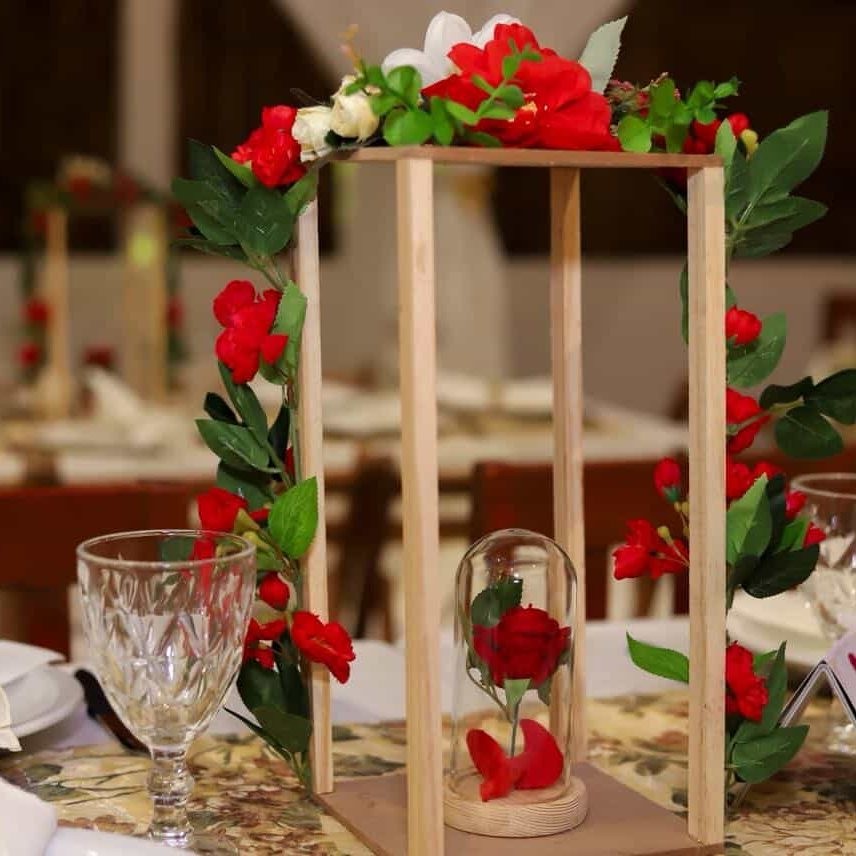 Centro de mesa con flores rojas y madera